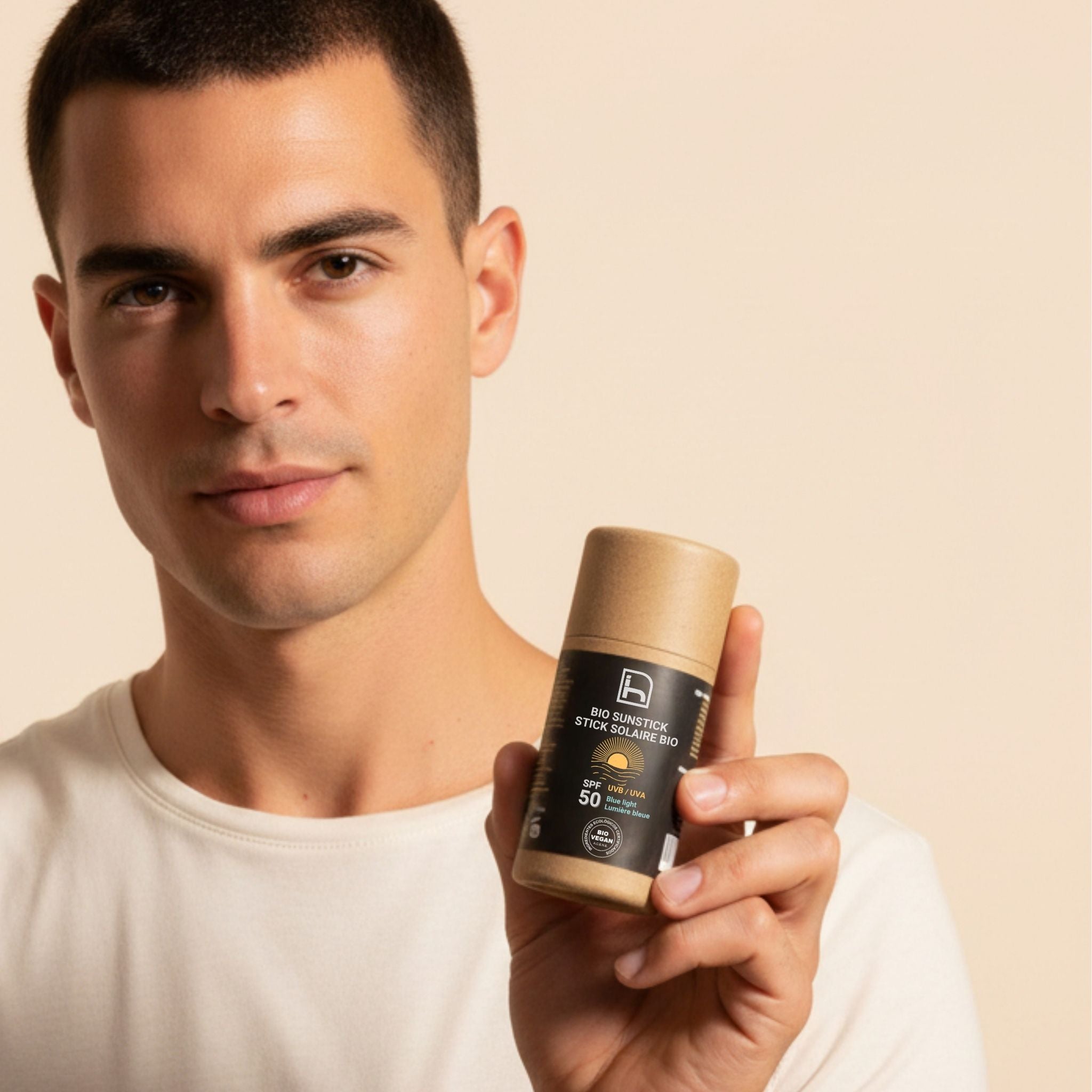 Hombre mostrando Bio Sunstick SPF50 de Homo Naturals, protector solar en stick diseñado para una aplicación práctica y cómoda en el rostro, labios y zonas sensibles localizadas.
