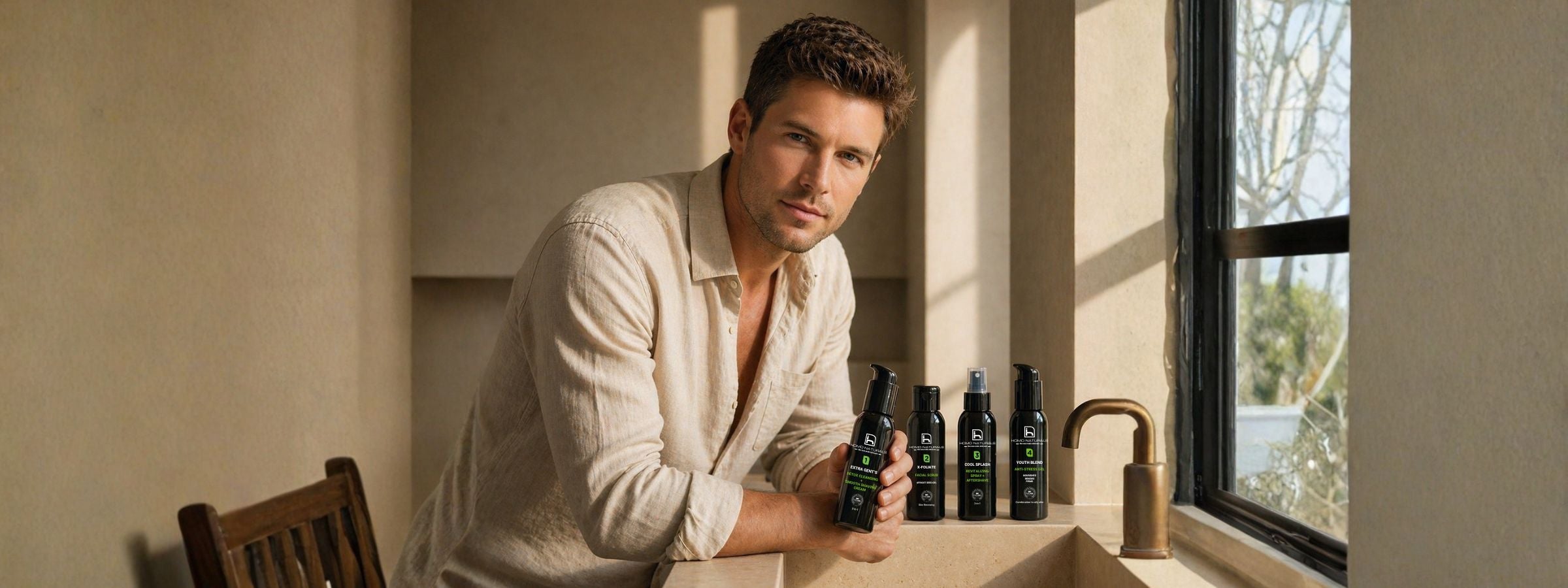 Hombre mostrando su ruitna de cuidado facial en 4 pasos compuesta de limpiador facial, exfoliante, tónico revitalizante en spray, y crema antiedad. Tratamiento antiarrugas natural con ácido hialurónico, bakuchiol, el retinol natural y péptidos reafirmantes. Fórmulas bio + vegan.