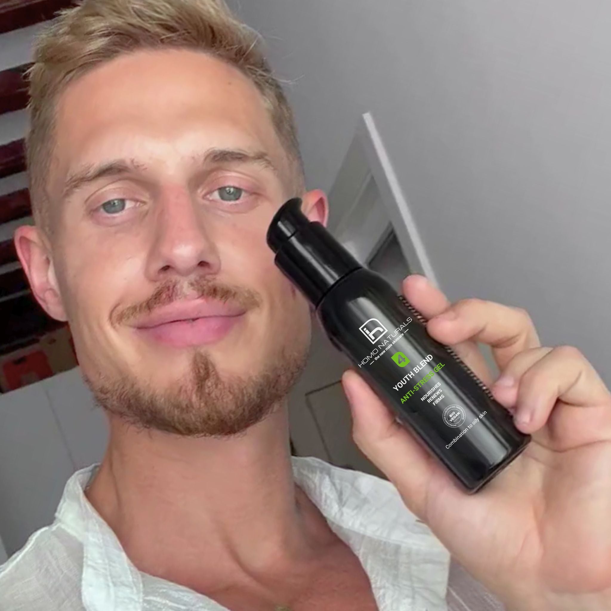 Hombre mostrando Crema facial de Homo Naturals, formulada para hidratar y ayudar a combatir los signos visibles de la edad. Especial para la piel del hombre y disponible en formato Gel y Crema. Sin derivados del petróleo. Con ácido hialurónico, péptidos y bakuchiol. Sin parabenos. Con certificación ecológica y vegana. No solo hidrata, también nutre y reafirma la piel del hombre.